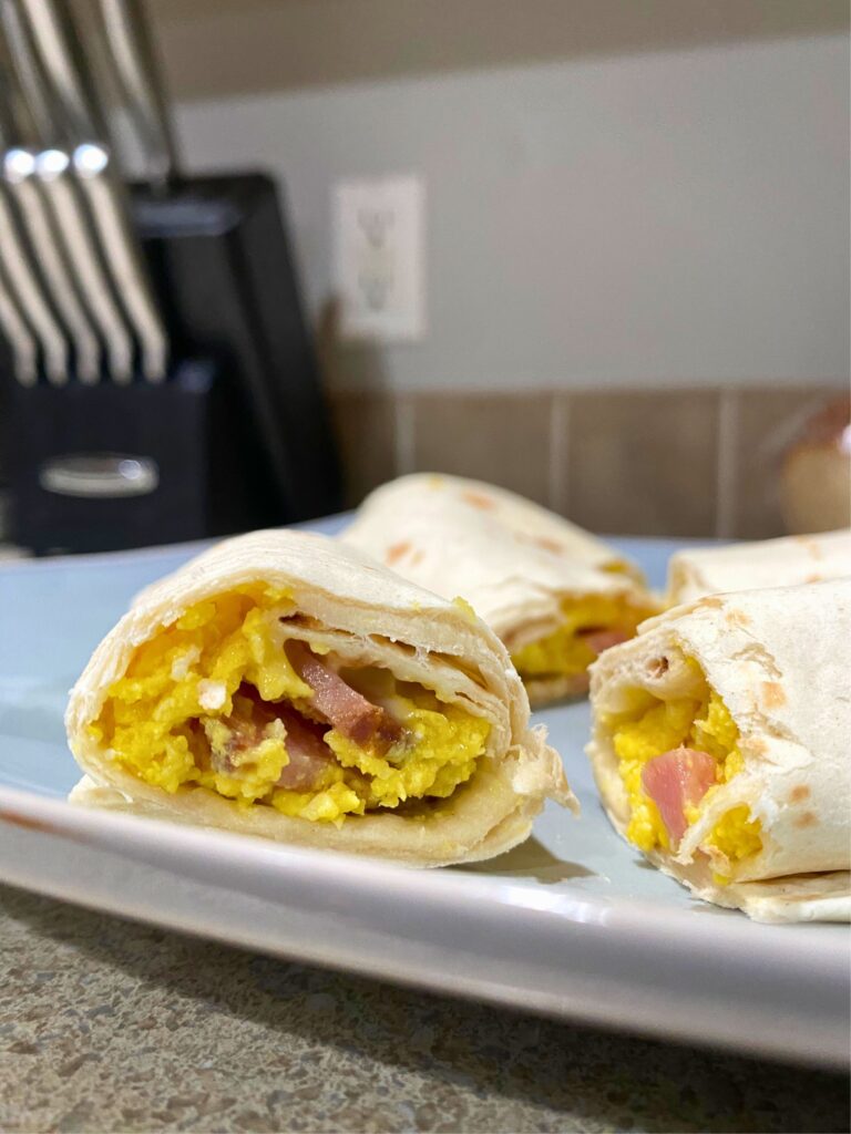 Egg, ham, and cheese burritos close-up on a plate