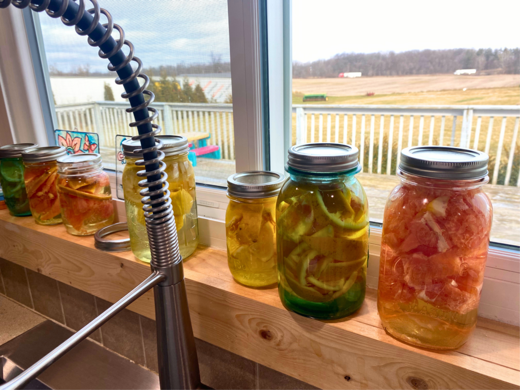 DIY Citrus-Scented Vinegar in mason jars on a window sill