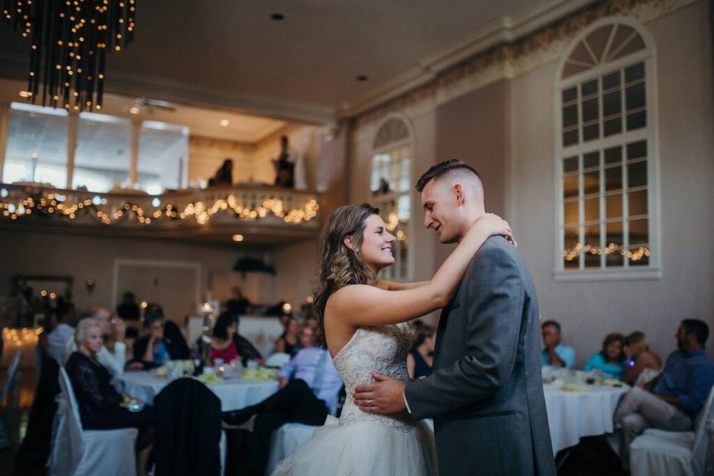 Newly married couple sharing their first dance surrounded by friends and family before the homestead story began