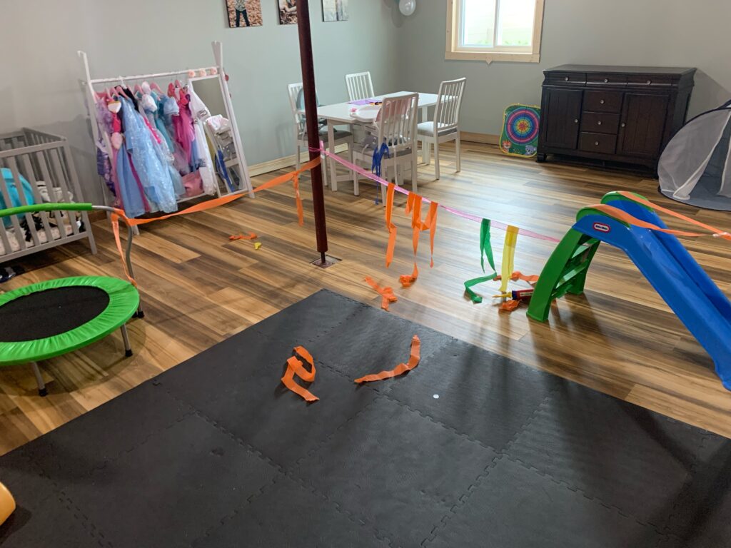 Basement kids play area decorated by children with orange paper streamers