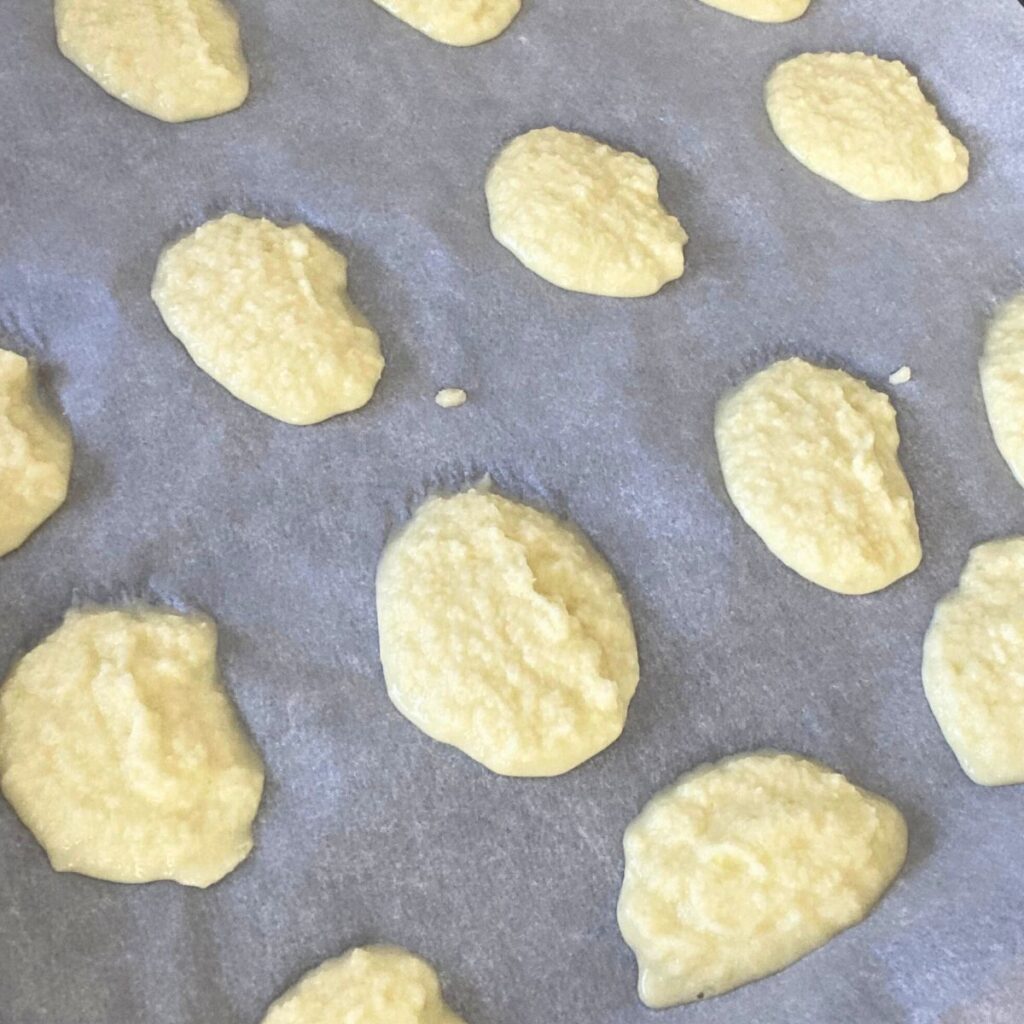 Minced onions in round disks (pucks) sitting on a baking sheet with parchment paper