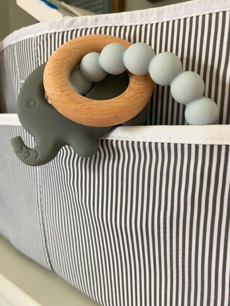 Clean elephant silicone baby toy with wooden ring stored in a diaper caddy